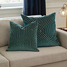 two sizes of teal green cut velvet geometric cushion, 45x45 and 55x55cm, sat together on a cream sofa.