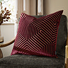 burgundy red cushion with geometric detailing, sat on dark khaki chair