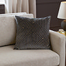 charcoal grey cushion with geometric detailing, sat in corner of cream sofa