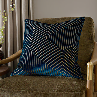 square navy cushion with geometric detail, sat on dark khaki chenille chair