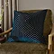 square navy cushion with geometric detail, sat on dark khaki chenille chair