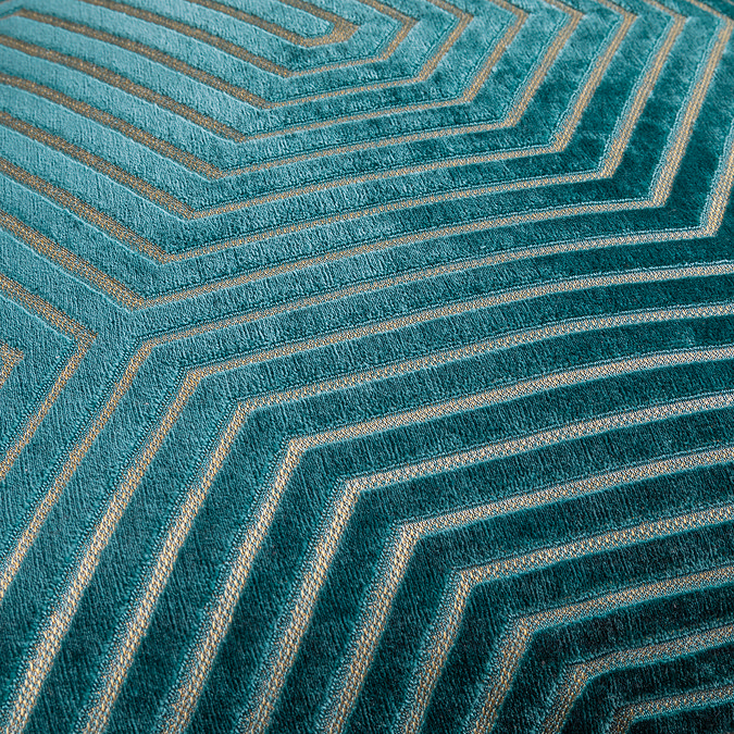close up on pattern of teal green cushion with gold geometric stitch detail