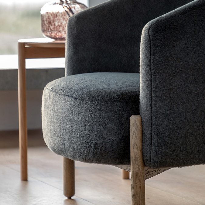 close up image of plush grey accent chair with ash wood legs