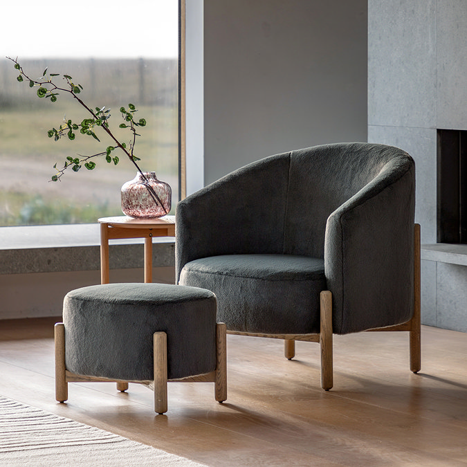 wide image of deep plush grey accent chair with matching stool, both with ash grey legs