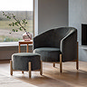 wide image of deep plush grey accent chair with matching stool, both with ash grey legs