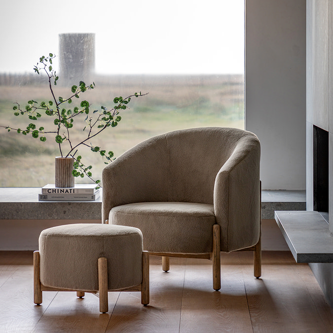 wide shot of soft khaki accent chair with ash wood legs, behind matching foot stool