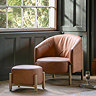 wide image of vintage brown leather accent chair with matching footstool