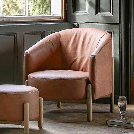 image of brown leather accent chair in font of dark green panelled wall
