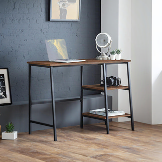 image of desk with black metal framework, walnut coloured surface with 2 open shelving spaces for storage or display, pushed up against slate blue wall
