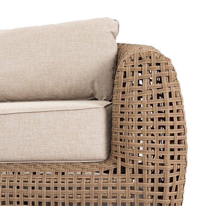 close up image on arm of rattan garden sofa with plush cream cushions