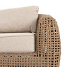 close up image on arm of rattan garden sofa with plush cream cushions