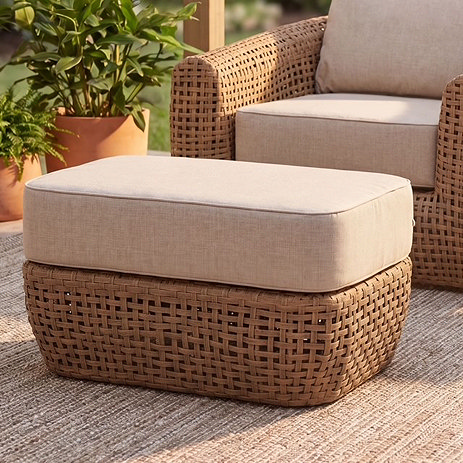 image of woven rattan garden footstool next to matching lounge chair