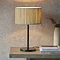 woven seagrass lamp with black steel base on a wooden side table