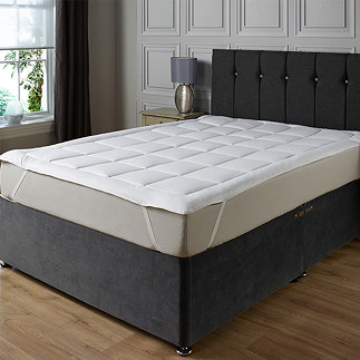 image of premium mattress topper over mattress on black fabric bed