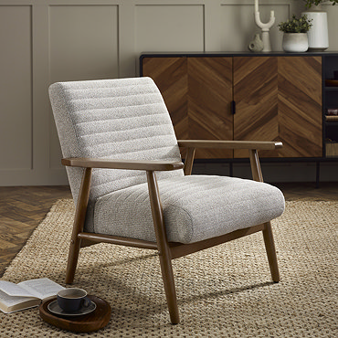 close up image of side of upholstered sand coloured accent chair with warm brown wooden arms and legs