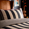 close up image of black and cream striped bedding