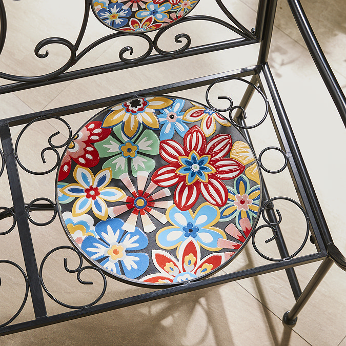 closeup image of wrought iron bench with mosaic pattern circle seat
