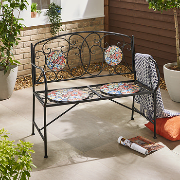 closeup image of wrought iron bench with mosaic pattern circle seat