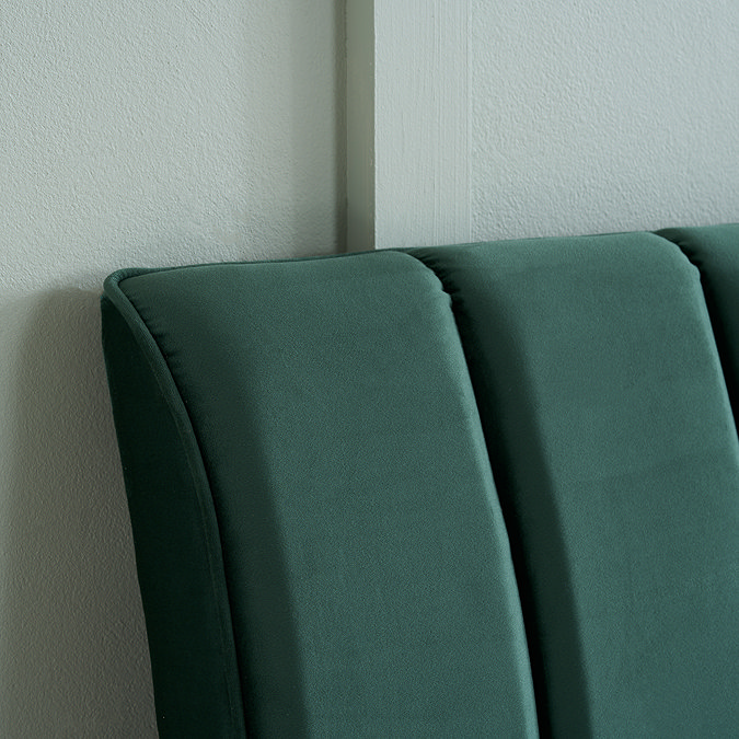 close up image on pleated emerald green velvet headboard of bed
