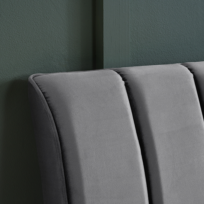 close up on grey velvet pleated headboard of double bed