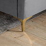 close up image of gold legs on grey velvet bed, on wood floor