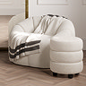 image of ivory boule pouffe with sculptural design, next to matching chair