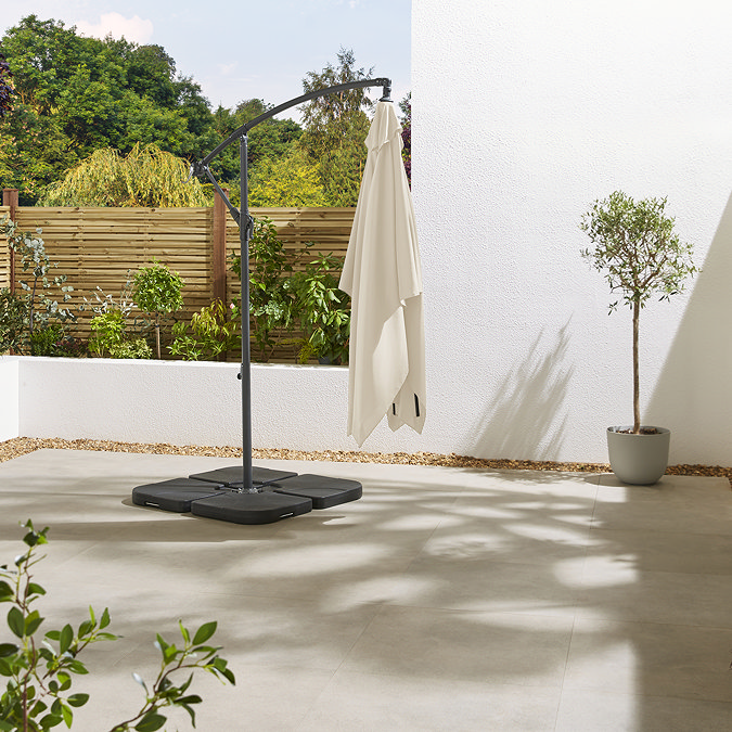 image of closed beige parasol on empty sunny patio