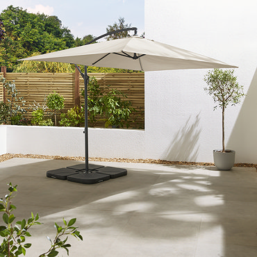 image of closed beige parasol on empty sunny patio