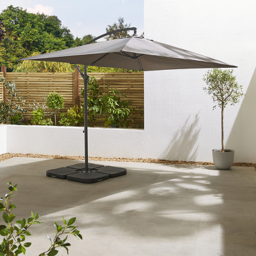 image of grey parasol closed and hanging from charcoal pole, on sunny patio