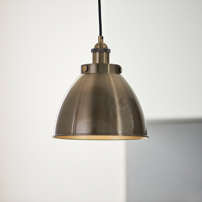 close up image of antique brass pendant light hanging from ceiling in kitchen