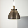 close up image of antique brass pendant light hanging from ceiling in kitchen