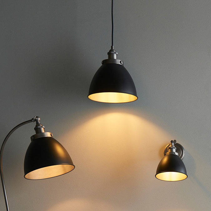 image of three black industrial style lighting options - 1 wall light, 1 floor lamp and 1 hanging pendant - against a light grey wall