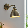 image of antique brass wall light on grey kitchen wall emitting warm light
