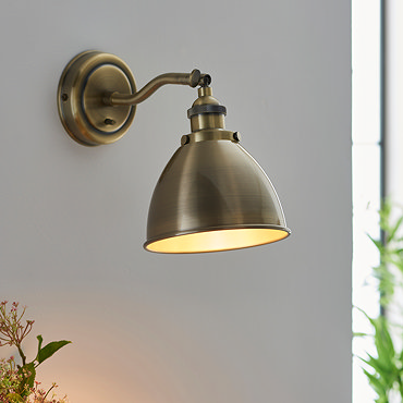 image of antique brass wall light on kitchen wall with matching pendant light hanging above kitchen table