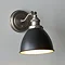 close up image of black and light grey wall light on grey wall