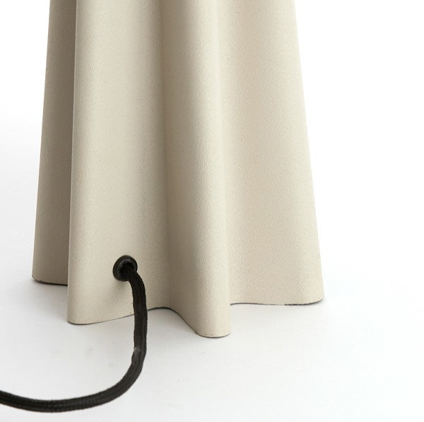close up image of base of matt beige lamp with sculptural form