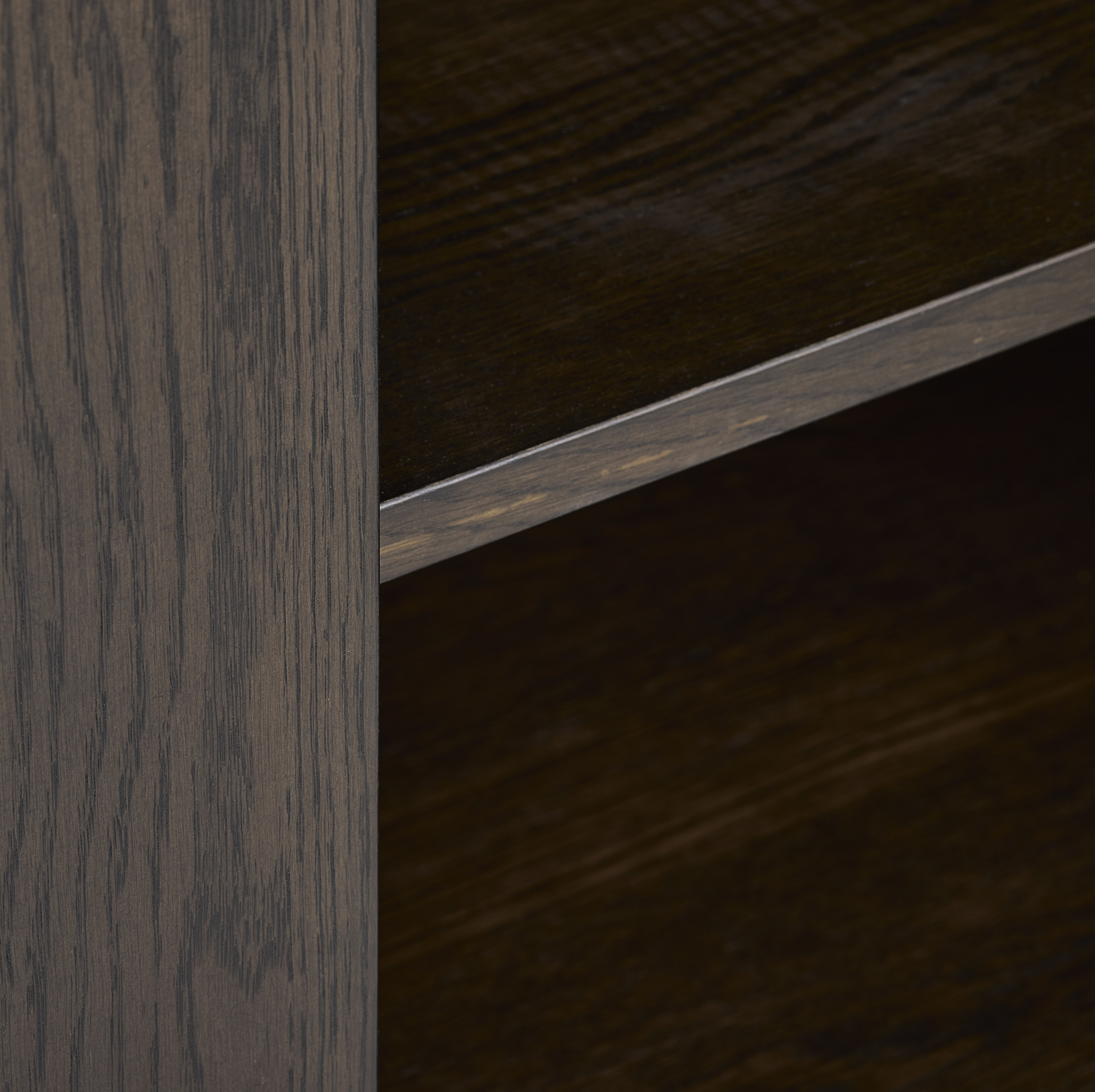 close up image on dark oak inner shelving of sideboard