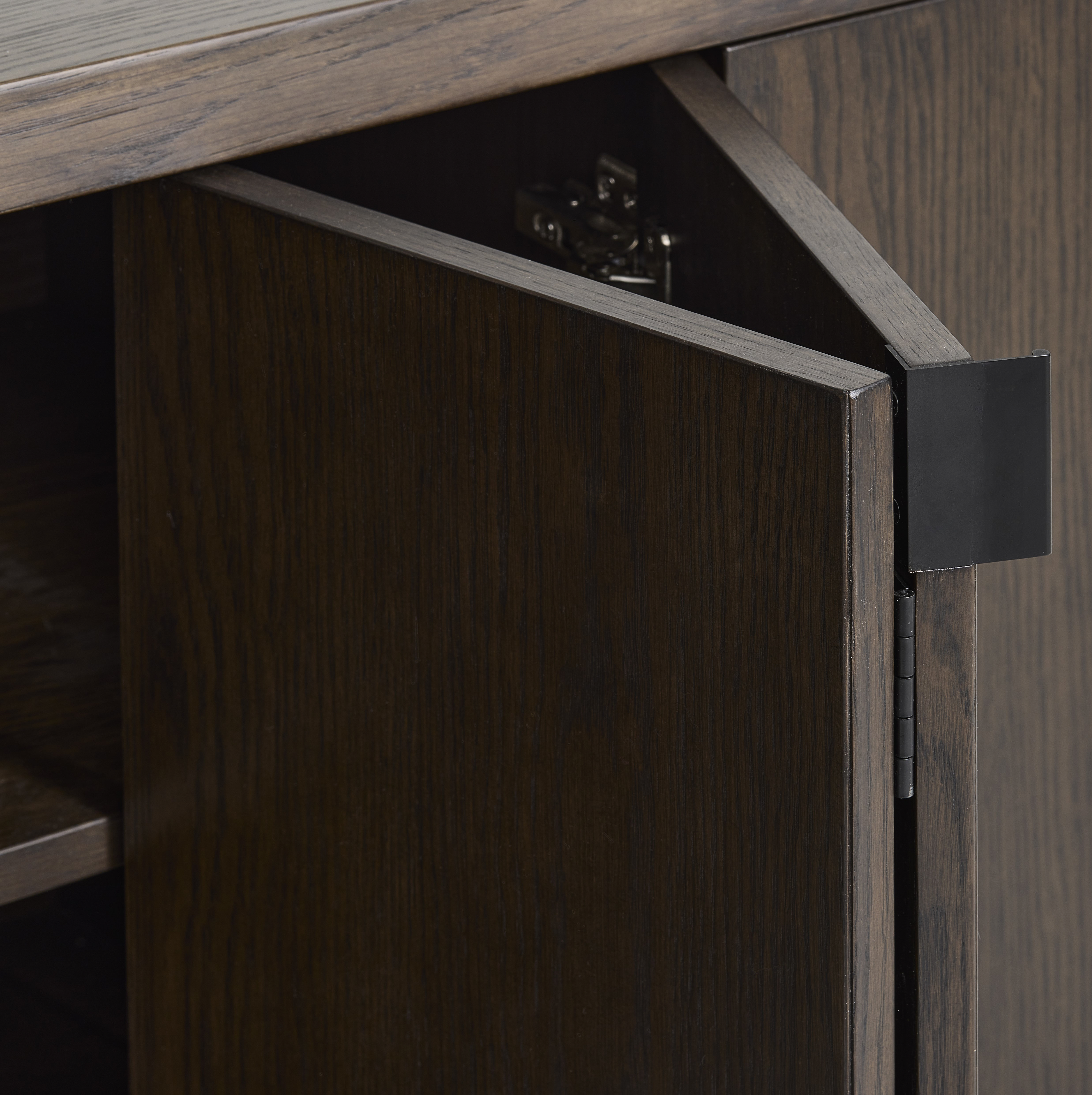 close up image of dark oak sideboard doors folded in, focus on smooth folds and hinge of the piece
