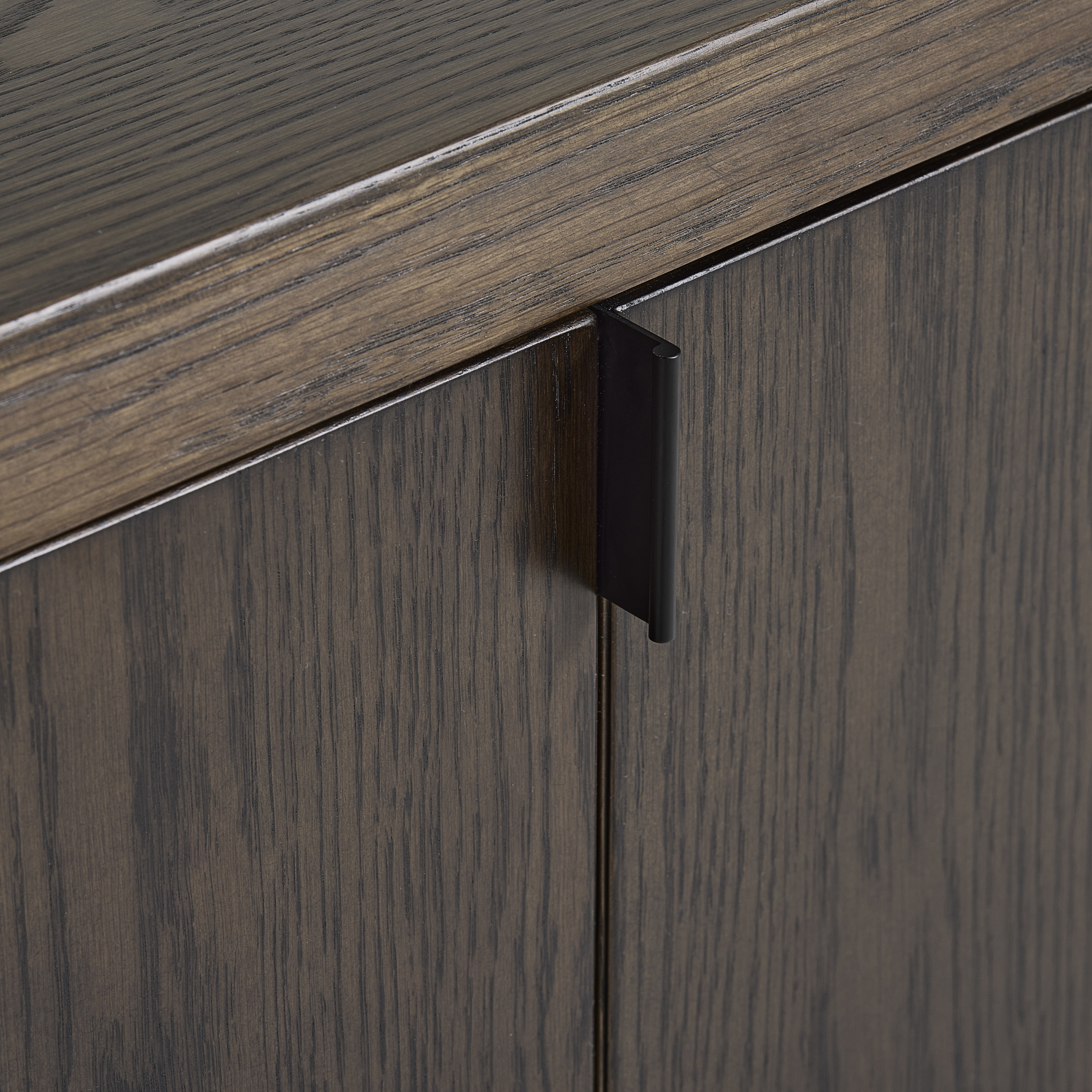 close up on front of espresso oak sideboard with subtle handle on top of a hinge for folding door feature