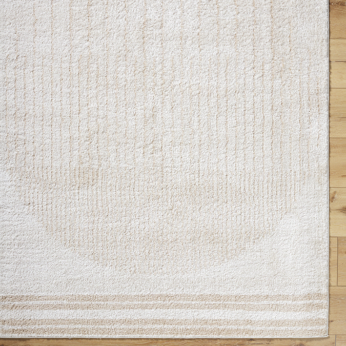 close up image of cream and beige rug with central modern circle design