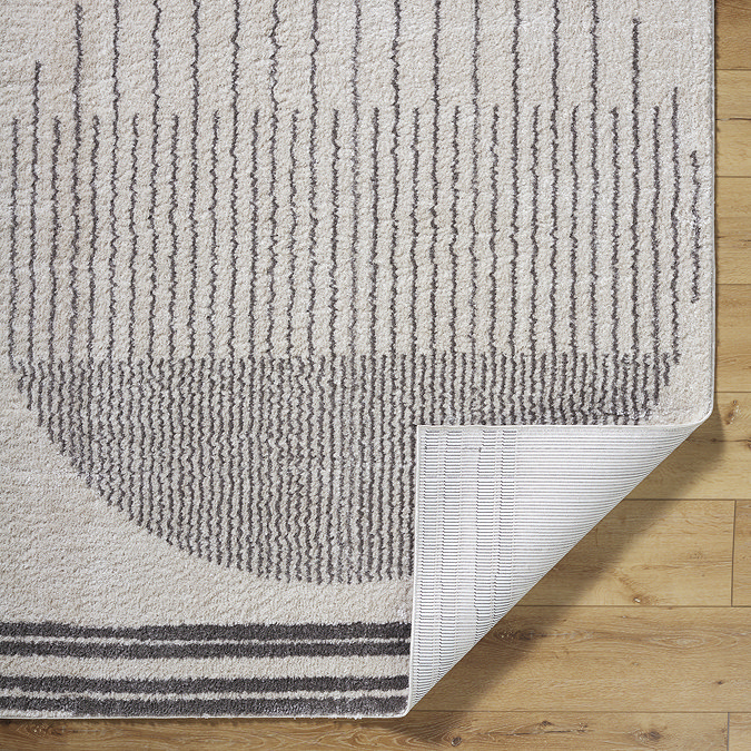 image of dark grey modern rug with corner folded up to show material underneath