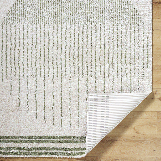 image of green and cream rug with corner folded over to show material underneath