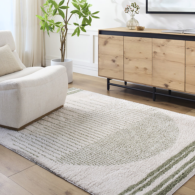 image of cream and green rug with central circle design, on light wood flooring