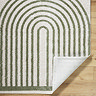 close up image of green and cream rug with corner folded over to show material underneath
