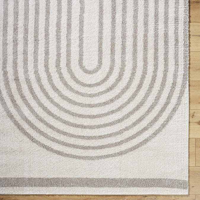 close up image of grey and cream rug with line arch pattern
