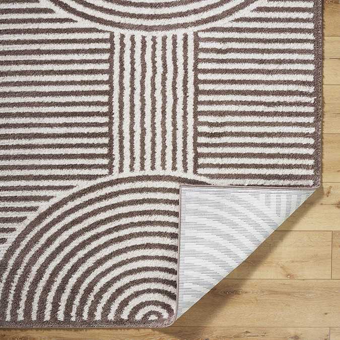 close up image of brown and cream soft rug folded over at the corner to show material underneath