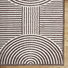 close up image of corner of cream and brown abstract rug