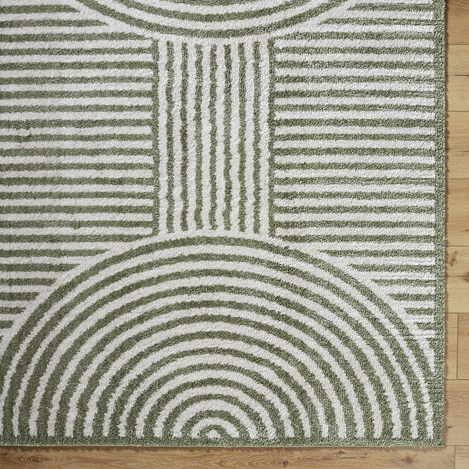 close up image of green and cream arch stripe rug, highlighting colour and texture
