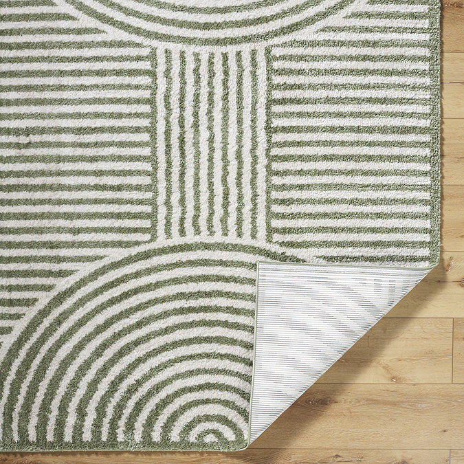 close up image of cream and green rug folded at the corner to reveal material underneath