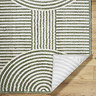 close up image of cream and green rug folded at the corner to reveal material underneath